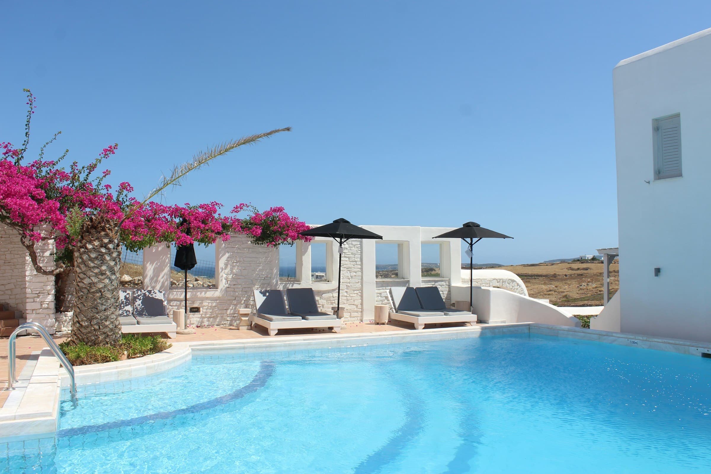 White Mediterranean villa with private pool and bougainvillea on a clear day